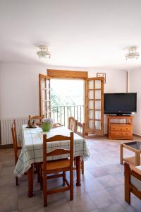 a dining room with a table and a television at Casa El Soldau in Naval
