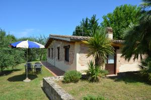 una pequeña casa con un paraguas azul y blanco en agriturismo contrada del raglio en Potenza Picena