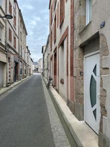 une rue vide dans une ruelle avec des bâtiments dans l'établissement Charmant Duplex en Centre-ville Proche du Puy-du-fouu, à Cholet