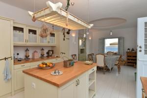 a kitchen with a island with a bowl of fruit on it at Bright Blue Villas-Villa Malinda in Aliki
