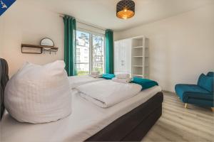 a bedroom with two beds and a blue couch at An der Haffküste Meerzeit in Zirchow