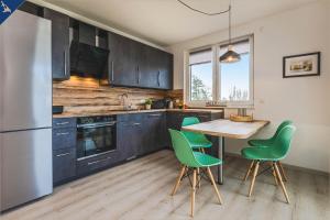 uma cozinha com uma mesa de madeira e cadeiras verdes em An der Haffküste Meerzeit em Zirchow