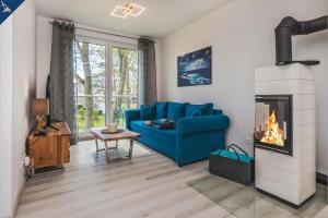 a living room with a blue couch and a fireplace at An der Haffküste Meerzeit in Zirchow