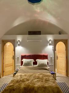 1 dormitorio con 1 cama grande y cabecero rojo en villa roswell marrakech, en Marrakech
