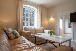 - un salon avec un canapé et une table dans l'établissement Gut Oehe, à Maasholm