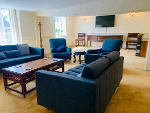 a living room with blue couches and a table at 4 Bed 17th century Coach House in Brasted