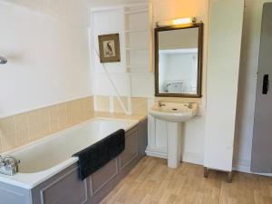a bathroom with a bath tub and a sink at 4 Bed 17th century Coach House in Brasted +18 photos
