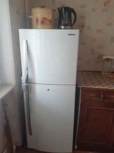 a white refrigerator in a kitchen next to a counter at 2-ух комнатная квартира in Baku