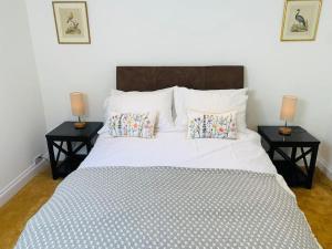 a bedroom with a large bed with two side tables at 4 Bed 17th century Coach House in Brasted