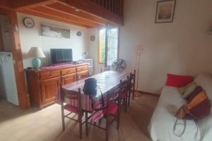 Una sala de estar con una mesa y sillas y un sofá. en Chalet dans un parc résidentiel de loisir - 0102, en Soulac-sur-Mer