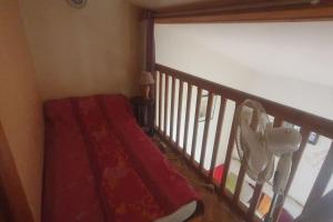 Una escalera con una manta roja y una ventana. en Chalet dans un parc résidentiel de loisir - 0102, en Soulac-sur-Mer
