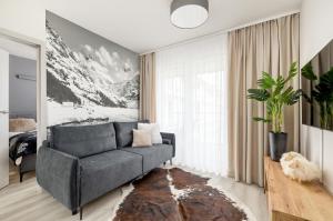 Una sala de estar con un sofá y una ventana grande. en Szymony Apartments Zakopane with SPA & Parking by Noclegi Renters, en Zakopane