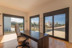a office with a desk and a chair and large windows at Llucmajor -1630 Mallorca in Llucmajor