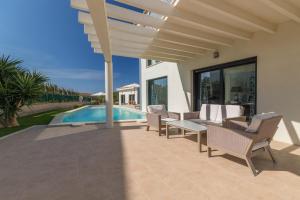 a patio with a table and chairs next to a swimming pool at Llucmajor -1630-21 Mallorca in Llucmajor