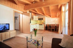 a living room with a kitchen and a table with a television at Appartement Angelika in Brixen im Thale