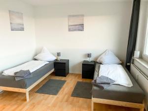 a room with two beds and two night stands at Cosy flat with TV & WLAN in Halle in Angersdorf