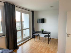 ein Wohnzimmer mit einem Schreibtisch und einem Fenster in der Unterkunft Cosy flat with TV & WLAN in Halle in Angersdorf