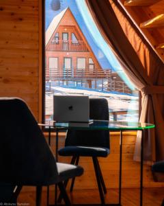 a table with a laptop on it in a room with a window at ALTO Cabins in Alamedin