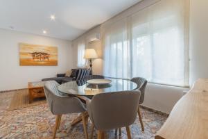 sala de estar con mesa, sillas y sofá en Manolete apartamento, en Jerez de la Frontera
