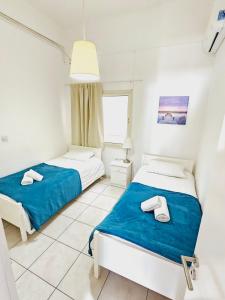 two beds in a white room with a window at Stephanie City Apartments in Larnaka +96 photos