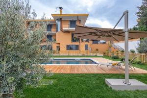 einen Hinterhof mit Pool und Sonnenschirm in der Unterkunft aura in Monte Porzio Catone