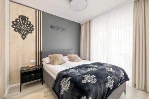 sypialnia z łóżkiem z czarno-białym kocem w obiekcie Szymony Apartments Zakopane with SPA & Parking by Renters w Zakopanem
