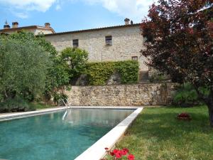 a swimming pool in a yard next to a building at Podere Sammonti in Monteriggioni