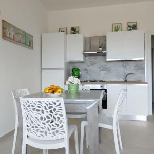 een keuken met een tafel met stoelen en een fruitschaal bij Costamia Casa Vacanze in Santa Maria di Castellabate