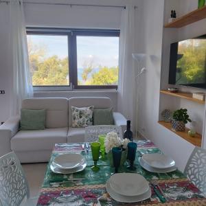 een woonkamer met een tafel en een bank bij Costamia Casa Vacanze in Santa Maria di Castellabate