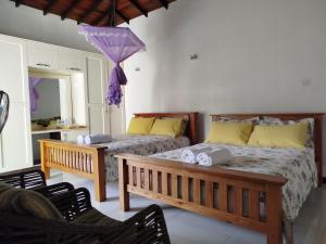 a bedroom with two beds and a bench and an umbrella at Boztreve Home in Kandy