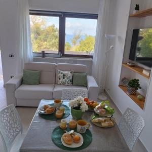 een woonkamer met een tafel met eten erop bij Costamia Casa Vacanze in Santa Maria di Castellabate
