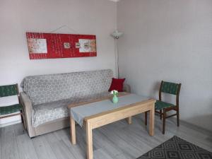 een woonkamer met een bank en een tafel en stoelen bij mieszkanie Tarnowskie Góry obok sądu in Tarnowskie Góry
