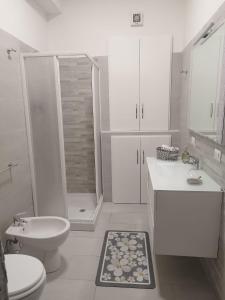 een witte badkamer met een toilet en een douche bij Costamia Casa Vacanze in Santa Maria di Castellabate