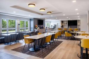 une salle à manger avec des tables et des chaises jaunes dans l'établissement Microtel Inn & Suites by Wyndham Kanata Ottawa West, à Kanata