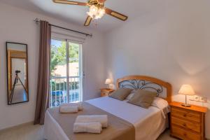 a bedroom with a bed with two towels on it at Puerto de Alcudia -2765 Mallorca in Port d'Alcudia