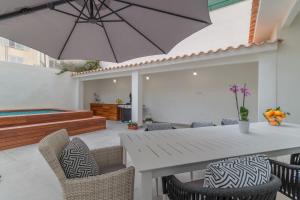 un patio con una mesa y sillas blancas y una sombrilla en Palma -2702 Mallorca en Palma de Mallorca