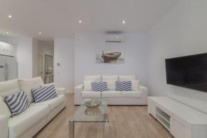 sala de estar con 2 sofás blancos y TV en Palma -2702 Mallorca, en Palma de Mallorca