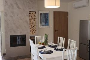 Un comedor con una mesa y sillas blancas. en Tündérkert Villa, en Balatonfőkajár