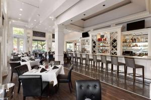 un restaurante con mesas y sillas y un bar en The Lafayette by LuxUrban en Nueva Orleans