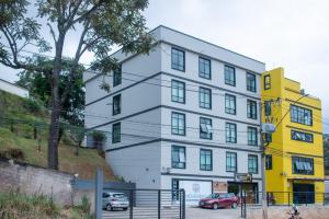 um edifício branco com um edifício amarelo em Hotel Regional JF em Juiz de Fora