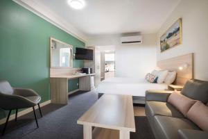 a hotel room with a bed and a couch and a table at Nightcap at Roxby Downs in Roxby Downs