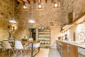 une cuisine avec une table et des chaises ainsi qu'un mur en pierre dans l'établissement Lloret de vistalegre -3065 Mallorca, à Lloret de Vistalegre