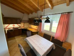 eine kleine Küche mit einem Tisch und einem Fenster in der Unterkunft Ferienwohnung Mark-Oehmen in Imst