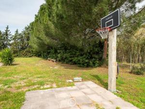 a basketball hoop with a net in a yard at Estay - Garden Paradise Escape - BBQ AirCon in Baratili San Pietro