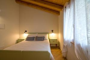 um quarto com uma cama branca e uma janela em Villa Mariolino em San Pellegrino Terme