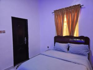 a bed in a room with a window and a bed sidx sidx sidx at Glory Apartment in Ibadan
