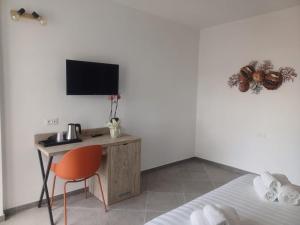 a bedroom with a desk with a bed and a television at Domo Annalisa in Àrbatax