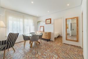 uma sala de jantar com uma mesa, cadeiras e um espelho em Manolete apartamento em Jerez de la Frontera mais 17 fotografias