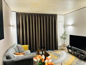 sala de estar con sofá y TV en Your London Escape Luxurious 1 Bedroom Apartment, en Londres