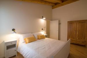a bedroom with a large white bed with two yellow pillows at Villa Mariolino in San Pellegrino Terme +19 photos